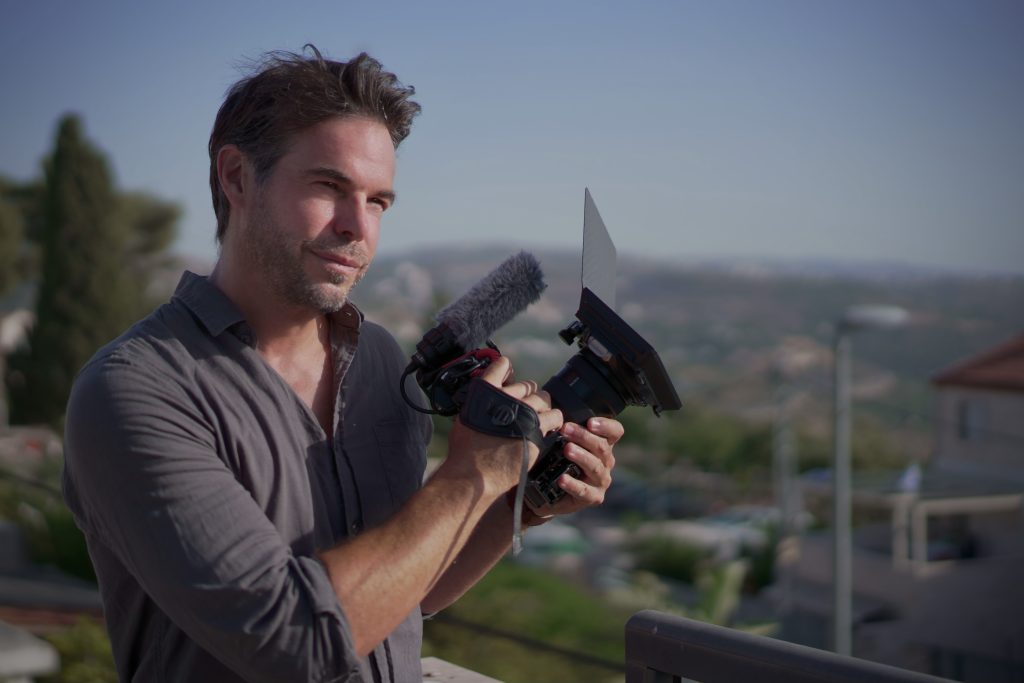 Marc D’Amours filming with a camera overlooking the city.